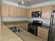 Modern kitchen with granite countertops, stainless steel appliances, and wood cabinetry at 8452 Boseck Dr # 216, Las Vegas, NV 89145