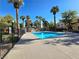 Community pool with palm trees and black fencing at 8452 Boseck Dr # 216, Las Vegas, NV 89145
