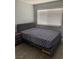 Bedroom featuring a Queen bed with a gray, plush headboard and a window with horizontal blinds at 904 Rockaway St, Las Vegas, NV 89145
