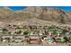 An aerial view showing mountain views, desert landscaping, pools, and a residential neighborhood at 931 Temple View Dr, Las Vegas, NV 89110