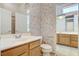 Bathroom featuring a white sink with wooden cabinets, a toilet, and access to a shower room at 931 Temple View Dr, Las Vegas, NV 89110