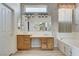 Bathroom showcasing dual sinks, tub and shower, bright lighting, and patterned wallpaper at 931 Temple View Dr, Las Vegas, NV 89110