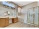 Bathroom boasts dual sinks, shower, soaking tub, and patterned wallpaper and flooring at 931 Temple View Dr, Las Vegas, NV 89110