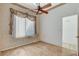 This bedroom has wood-look floors, a ceiling fan, and a window letting in bright sunlight at 931 Temple View Dr, Las Vegas, NV 89110