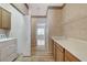 Bright laundry room includes wood floors, shelving, a utility sink with cabinets, and washer/dryer at 931 Temple View Dr, Las Vegas, NV 89110