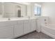 Ensuite bathroom features a double sink vanity and separate tub with tile flooring at 9339 Bondeno St, Las Vegas, NV 89123