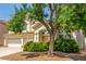 Inviting home featuring a 3-car garage and mature trees in the front yard at 9339 Bondeno St, Las Vegas, NV 89123