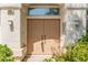 Close-up of the home's double-door entryway, highlighted by modern sconces and decorative bushes at 9339 Bondeno St, Las Vegas, NV 89123