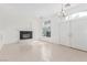 Bright living room with fireplace, chandelier, and double doors leading to the exterior at 9339 Bondeno St, Las Vegas, NV 89123