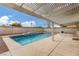A covered outdoor patio next to this sparkling blue pool adds more outdoor living space at 9339 Bondeno St, Las Vegas, NV 89123