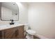 Bathroom featuring a wood vanity, black hardware, and a decorative mirror at 1069 Silver Bullet Ct, Henderson, NV 89011