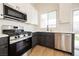 The kitchen features stainless steel appliances, white quartz countertops, and shaker style cabinets at 1069 Silver Bullet Ct, Henderson, NV 89011
