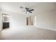 Spacious primary bedroom with ceiling fan, plush neutral carpet and ensuite bathroom at 1069 Silver Bullet Ct, Henderson, NV 89011