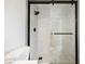 Modern shower featuring a glass door, black fixtures, and stylish gray tile at 1069 Silver Bullet Ct, Henderson, NV 89011