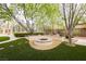 Backyard featuring a fire pit, manicured landscaping, and artificial turf at 10726 Hawes End Ct, Las Vegas, NV 89183
