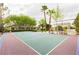 A full-sized backyard basketball court with seating and landscaping surrounding the perimeter at 10726 Hawes End Ct, Las Vegas, NV 89183