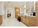 Bright bathroom with double vanities, framed mirrors, marble floors, and a view into the main bedroom at 10726 Hawes End Ct, Las Vegas, NV 89183