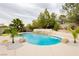 Backyard pool area featuring a pristine pool with rock accents, and lush landscaping at 10726 Hawes End Ct, Las Vegas, NV 89183
