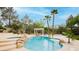 Backyard lagoon pool with a swim-up bar, sun loungers, and palm trees at 10726 Hawes End Ct, Las Vegas, NV 89183