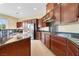 Kitchen with dark wood cabinets, granite countertops, stainless appliances, and dual-basin sink at 1111 Casa Palermo Cir, Henderson, NV 89011