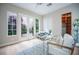 Bright home office with glass desk, built-in shelving, and French doors leading to a private outdoor space at 11359 Winter Cottage Pl, Las Vegas, NV 89135