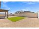 Wide view of a backyard with gravel, artificial grass, and a covered patio at 13 Deseo Ct, North Las Vegas, NV 89031