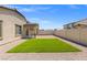Large backyard featuring gravel landscaping, artificial grass, and a covered patio at 13 Deseo Ct, North Las Vegas, NV 89031