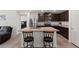 Open kitchen with stainless steel appliances, granite countertops, and dark wood cabinets at 13 Deseo Ct, North Las Vegas, NV 89031