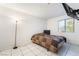 Bright bedroom with white tile, a large window with blinds, and a mounted TV at 1361 E University Ave # 106, Las Vegas, NV 89119