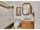 Modern bathroom featuring a tub with a glass screen, vanity with wooden cabinets, and black and white accents at 1805 Prichard Ave, Henderson, NV 89052