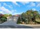 Charming single-story home featuring a three-car garage, tile roof, and lush, mature landscaping at 1805 Prichard Ave, Henderson, NV 89052