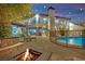 Expansive backyard oasis with a pool, outdoor seating, fire pit, and manicured landscaping, ideal for relaxation at 2208 Point Rock Ln, Las Vegas, NV 89134