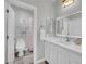 Bright bathroom featuring a modern marble-style vanity, sink, white cabinets, and an open shower at 2208 Point Rock Ln, Las Vegas, NV 89134
