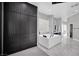 Bright bathroom featuring a luxurious soaking tub, extensive cabinetry, and marble floors at 2208 Point Rock Ln, Las Vegas, NV 89134