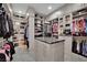 Custom closet featuring drawers, shelving and clothes racks, plus a central island with granite countertop at 2208 Point Rock Ln, Las Vegas, NV 89134