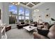 Bright living room with high ceilings, large arched windows, and comfortable leather furniture at 2208 Point Rock Ln, Las Vegas, NV 89134