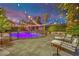 Backyard oasis featuring a pool, fire pit, lounge chairs, and lush landscaping under string lights at 2208 Point Rock Ln, Las Vegas, NV 89134