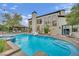 Large pool with attached hot tub and slide in backyard with covered patio, outdoor kitchen and seating at 2208 Point Rock Ln, Las Vegas, NV 89134