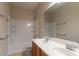 Bathroom featuring a double sink vanity, large mirror, and a shower-tub combo with tiled walls at 2532 Bechamel Pl, Henderson, NV 89044