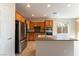 Bright kitchen features wooden cabinets, stainless steel appliances and island sink at 2532 Bechamel Pl, Henderson, NV 89044