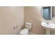 Well-lit powder room featuring a toilet, sink with faucet, oval mirror, and neutral wall color at 2532 Bechamel Pl, Henderson, NV 89044