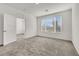 A carpeted bedroom has natural light from a window and an open doorway at 2555 Hampton Rd # 10104, Henderson, NV 89052