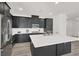 Modern kitchen featuring stainless steel appliances, dark cabinets, and a large white quartz island at 2555 Hampton Rd # 10104, Henderson, NV 89052
