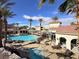 A serene community pool and spa with lounge chairs provide a relaxing oasis amid palm trees and buildings at 2555 Hampton Rd # 10104, Henderson, NV 89052