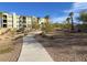 A beautifully landscaped walking path winds through the community, leading residents towards mountain views and the building at 2555 Hampton Rd # 10104, Henderson, NV 89052
