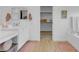 Bathroom offers dual sinks, white cabinetry, wood flooring, and access to a walk-in closet at 272 Mount Steele Ave, Henderson, NV 89015