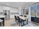 Modern dining room with stainless steel appliances, a stylish table, and ample natural light from large windows at 272 Mount Steele Ave, Henderson, NV 89015