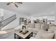 Spacious living area featuring hardwood floors, a comfortable sofa, a modern staircase and an adjacent kitchen at 272 Mount Steele Ave, Henderson, NV 89015