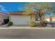 Tan single-story home featuring a red tile roof, low maintenance landscaping, and attached two-car garage at 2852 Red Ct, Las Vegas, NV 89123