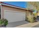 Close up of an attached two-car garage with a concrete driveway and small bushes in front at 2852 Red Ct, Las Vegas, NV 89123